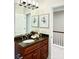 Bathroom with granite countertop, wooden cabinets, mirror, and decorative artwork at 735 Amalfi Dr, Davidson, NC 28036