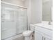 Bathroom with a glass door shower, white cabinets, and a modern toilet at 10500 Bradstreet Commons Way, Charlotte, NC 28215