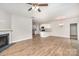 Open-concept living space with hardwood floors, a fireplace, and a view of the modern kitchen at 10500 Bradstreet Commons Way, Charlotte, NC 28215