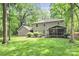 Backyard view of a home with a screened porch and green lawn surrounded by mature trees at 11 Tanglewood Rd, Lake Wylie, SC 29710