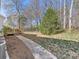 Landscaped backyard with stone walkway, mature trees, and wooden deck at 111 Forest Walk Way, Mooresville, NC 28115