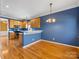 Inviting dining area with hardwood floors, a modern chandelier, and an open view to the adjacent kitchen at 111 Forest Walk Way, Mooresville, NC 28115