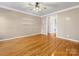 Spacious living room boasts hardwood floors, two white floating shelves, and neutral paint creating a cozy atmosphere at 111 Forest Walk Way, Mooresville, NC 28115