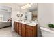 Double sink vanity with wood cabinets in bathroom with access to Main Bedroom at 12124 Red Rust Ln, Charlotte, NC 28277