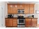 Kitchen featuring stainless steel oven, stainless steel microwave, and wood cabinets at 12124 Red Rust Ln, Charlotte, NC 28277