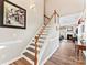 Inviting staircase with wooden handrail and open floor plan into living room with fireplace at 12124 Red Rust Ln, Charlotte, NC 28277