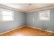 Bedroom with light-blue wallpaper, hardwood floors, and two windows for natural light at 126 Regal Cir # 2122, Mooresville, NC 28115