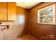 The mudroom features wood-paneled walls, cabinets, and a window for natural light at 126 Regal Cir # 2122, Mooresville, NC 28115