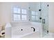 Elegant bathroom featuring a glass shower, garden tub, white marble accents, and plantation shutters at 1316 Valhalla Dr, Denver, NC 28037