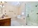 Spa-like bathroom featuring a glass shower, garden tub, white marble accents, and an elegant vanity at 1316 Valhalla Dr, Denver, NC 28037
