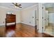 Bedroom featuring hardwood floors, a headboard, and multiple doorways leading to en-suite baths and closets at 1316 Valhalla Dr, Denver, NC 28037