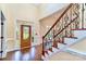 Elegant foyer with hardwood floors, staircase with iron railings, and a stained-glass front door at 1316 Valhalla Dr, Denver, NC 28037