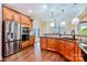 Gourmet kitchen featuring stainless steel appliances, rich wood cabinets, and designer lighting at 1316 Valhalla Dr, Denver, NC 28037