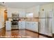 Modern kitchen with stainless steel appliances and white cabinets offers an efficient cooking space with hardwood floors at 1316 Valhalla Dr, Denver, NC 28037