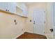 Bright laundry room features white cabinets, wood-look tile flooring, and a convenient layout, enhancing home functionality at 1316 Valhalla Dr, Denver, NC 28037
