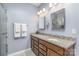 Bathroom features a dual sink vanity with granite countertop and tiled floors, and a glass door shower at 1512 Brooksland Pl, Waxhaw, NC 28173