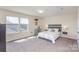 Bright bedroom featuring carpeted floors, two windows and a rustic-style headboard above the bed at 1512 Brooksland Pl, Waxhaw, NC 28173
