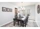 Elegant dining room features a dark wood table, chandelier lighting, and neutral décor, perfect for Gathering gatherings at 1512 Brooksland Pl, Waxhaw, NC 28173