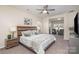 This main bedroom features a ceiling fan, artwork and a sitting room area at 1512 Brooksland Pl, Waxhaw, NC 28173