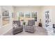 This sunroom has two gray chairs, three windows, and a glass door to the outside at 1512 Brooksland Pl, Waxhaw, NC 28173