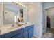 This bathroom has double sinks with a blue vanity and a mirror with lighting above the sinks at 155 Gray Cliff Dr, Mooresville, NC 28117