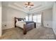 This bedroom has a tray ceiling with ceiling fan and a brown wood bed frame with blue pillows and bedding at 155 Gray Cliff Dr, Mooresville, NC 28117