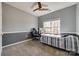 This bedroom has gray walls with white trim, ceiling fan, and a twin bed with a window to the side at 155 Gray Cliff Dr, Mooresville, NC 28117