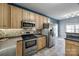 Open-concept kitchen with light wood cabinets, stainless steel appliances, and tile flooring at 155 Gray Cliff Dr, Mooresville, NC 28117