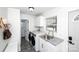 Well-lit laundry room featuring modern washer and dryer, sink with granite countertop, and tiled flooring at 1615 Stack Rd, Monroe, NC 28112