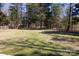 Expansive backyard with lush green space, mature trees, and a wooden fence, ideal for recreation at 1717 Deer Run Rd, Catawba, SC 29704