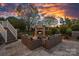 Backyard patio with stone fireplace and wicker seating provides a luxurious and comfortable outdoor gathering space for relaxation and enjoyment at 19216 Peninsula Shores Dr, Cornelius, NC 28031
