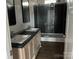Modern bathroom featuring double sink vanities, sliding glass shower doors, and black tile at 2070 Travis Rd, Conover, NC 28613
