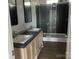 Modern bathroom featuring double sinks, wood cabinets, and a spacious tiled shower with glass door at 2070 Travis Rd, Conover, NC 28613