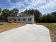 Charming single-story home with light gray siding, black shutters, and a newly constructed concrete driveway at 2070 Travis Rd, Conover, NC 28613