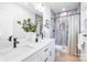 Bathroom featuring a double sink vanity, modern fixtures, and tile shower with curtain at 2544 Pinestream Dr, Charlotte, NC 28216