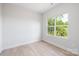 Bright, empty bedroom featuring hardwood floors and a window for natural light at 2544 Pinestream Dr, Charlotte, NC 28216
