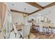 An open-concept dining area with wood floors, exposed beams, stylish chairs, and a breakfast bar at 2604 Lamplighter Dr, Kannapolis, NC 28081