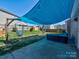 Backyard features a shady canopy with hanging lights, a patio set, and hammocks for relaxing at 3426 Dominion Green Dr, Charlotte, NC 28269