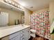 A bathroom with white vanity, large mirror, shower with colorful curtain, and wood-look flooring at 3426 Dominion Green Dr, Charlotte, NC 28269