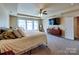 Relaxing bedroom with a ceiling fan, a large tv, and lots of windows to let natural light in at 3426 Dominion Green Dr, Charlotte, NC 28269