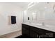 Well-lit bathroom featuring a double sink vanity, towel racks, and a shower with glass door at 353 Webb Farm Rd, Shelby, NC 28152