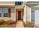 Home's entrance features red front door, well-maintained landscaping, and a covered entryway at 353 Webb Farm Rd, Shelby, NC 28152