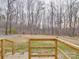 Peaceful view of the backyard from the deck, showcasing a large open lawn and a backdrop of tall, bare trees at 40701 Nc 740 Hwy, New London, NC 28127