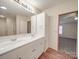 Bright bathroom featuring a double sink vanity, a large mirror, and wood-style flooring at 40701 Nc 740 Hwy, New London, NC 28127