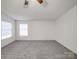 A cozy bedroom featuring carpet, neutral tones, a ceiling fan, and natural light at 40701 Nc 740 Hwy, New London, NC 28127