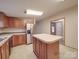 Bright kitchen features wood cabinets, center island, stainless steel appliances, and vinyl flooring at 40701 Nc 740 Hwy, New London, NC 28127