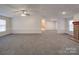 Large living room with fireplace, neutral carpet, ceiling fan, and an open layout leading to other areas of the house at 40701 Nc 740 Hwy, New London, NC 28127