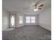 Bright living room featuring neutral carpeting, modern ceiling fan, and ample natural light from multiple windows at 40701 Nc 740 Hwy, New London, NC 28127