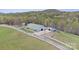 Aerial view of barn, outbuildings, white fencing, and surrounding landscape at 447 Willow Pond Ln, Hiddenite, NC 28636
