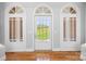 Elegant entryway featuring a front door framed by sidelights, enhancing natural light and architectural detail with hardwood floors at 447 Willow Pond Ln, Hiddenite, NC 28636
